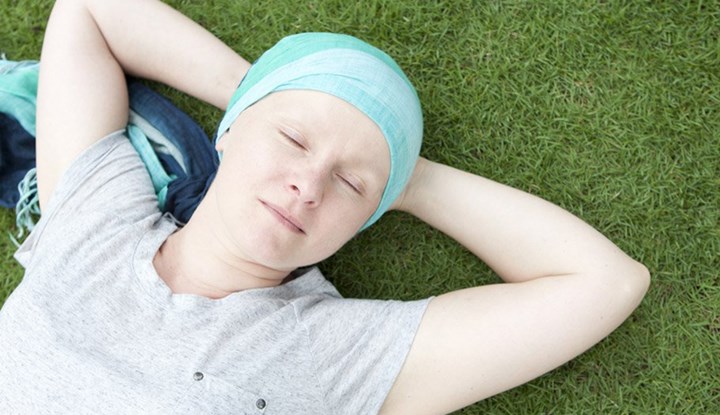 Young woman with head scarf lying in the grass